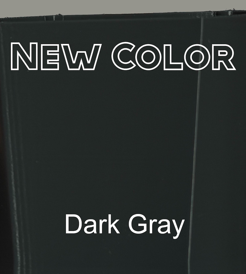 Op de afbeelding: Een effen donkergrijs oppervlak met de tekst NEW COLOR in wit omrande hoofdletters bovenaan en de tekst Dark Gray in een wit schreefloos lettertype in het midden eronder, wat een nieuwe kleuroptie voor een product of materiaal aangeeft.
