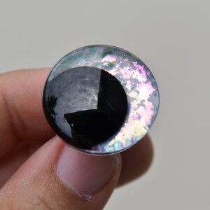 以下が含まれることがあります： 黒色の瞳孔を持つ、丸い黒と虹色のプラスチック製の目。目はキラキラと虹色に輝いています。