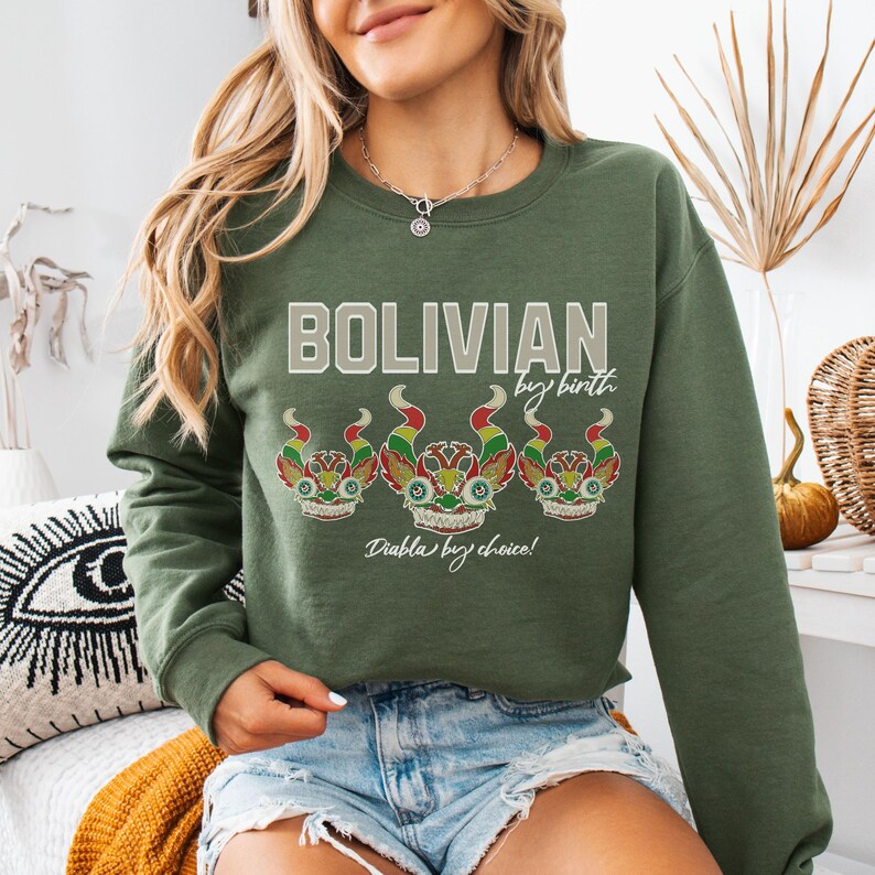 May include: Green sweatshirt with the text "Bolivian by birth, Diablo by choice!" and a row of three colorful, stylized faces.