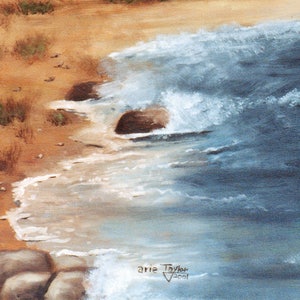 May include: An oil painting depicts a coastal scene with a sandy beach, ocean waves, and rocks. The water is a mix of blues and whites, crashing against the shore. The sand is a warm tan color. The artist's signature and the year 2001 are visible in the lower right corner.