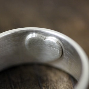 Puede incluir: Anillo de plata con un corte en forma de corazón en el interior de la banda.