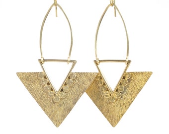 Peut inclure: Une paire de boucles d'oreilles géométriques dorées avec une forme triangulaire et une finition texturée. Les boucles d'oreilles ont un design suspendu avec un petit détail circulaire.