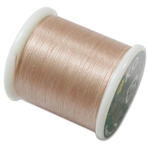 May include: A spool of light pink waxed thread for leather crafting. The spool is labelled "C.R. 0.5mm".