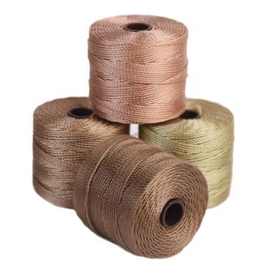 May include: Four spools of embroidery floss in shades of brown and green. The spools are stacked on top of each other.