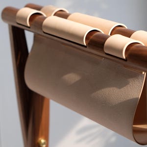 May include: A wooden chair with a light brown leather seat and back. The chair has a simple, modern design and is made of high-quality materials.