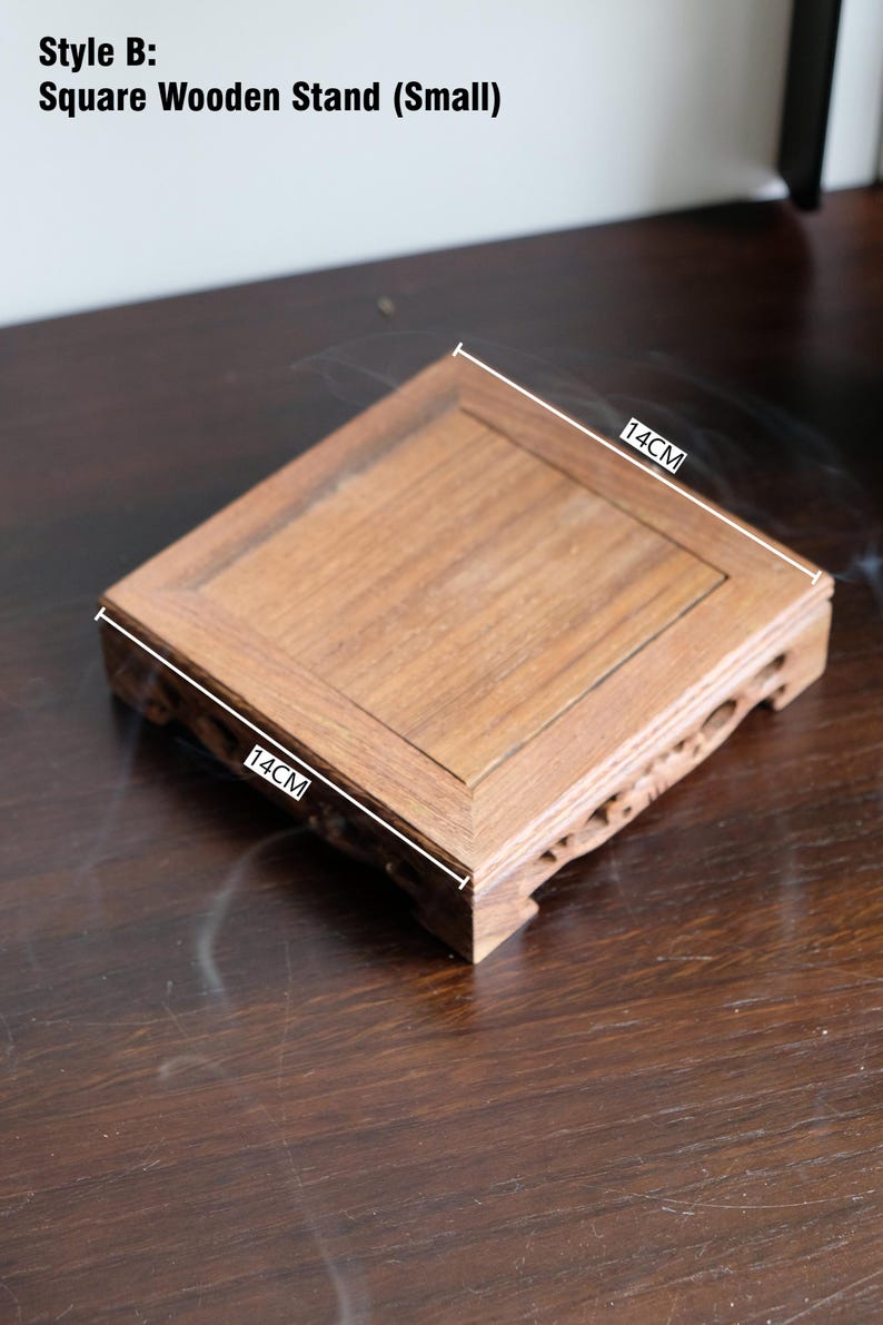 May include: A small, square wooden stand with a natural wood finish. The stand measures 14 inches by 14 inches.
