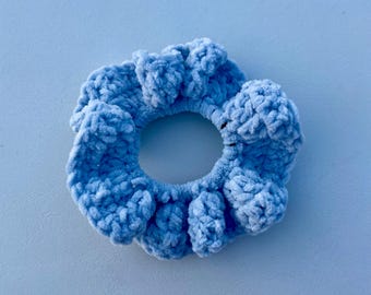 May include: A light blue fuzzy scrunchie made of crocheted yarn.