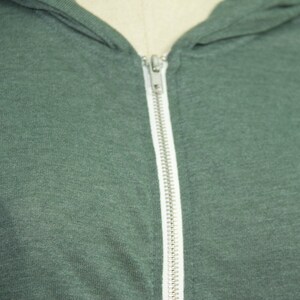 May include: A dark green hooded sweatshirt with a zipper closure.