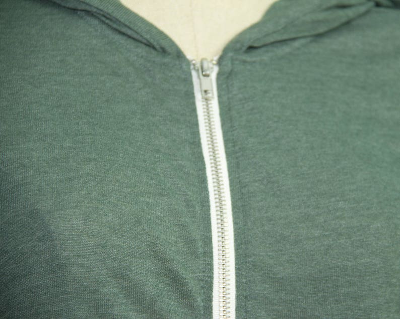 May include: A dark green hooded sweatshirt with a zipper closure.