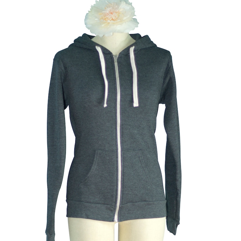 May include: A dark gray zip-up hoodie with a white zipper and white drawstrings.