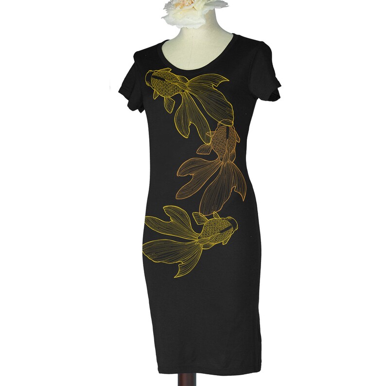 May include: Black dress with a gold and orange outline of three goldfish on the front.