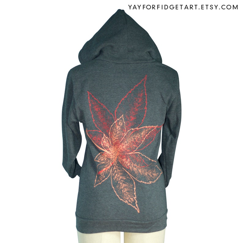 May include: A charcoal grey zippered hoodie with a large red and orange leaf print on the back.