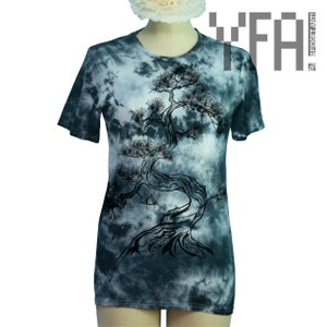 以下が含まれることがあります： 白地に黒いシルエットの盆栽の木が描かれたタイダイ染めのTシャツ。Tシャツは薄い青色で、白と灰色のタイダイ模様になっています。