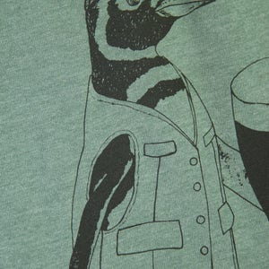 May include: A green t-shirt with a black and white illustration of a penguin wearing a vest and holding a glass of beer.