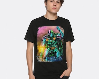 May include: Black t-shirt featuring a colorful graphic of a hooded figure in green and blue armor. The illustration has a comic book style with a pink and yellow background. The figure is kneeling with one arm raised.