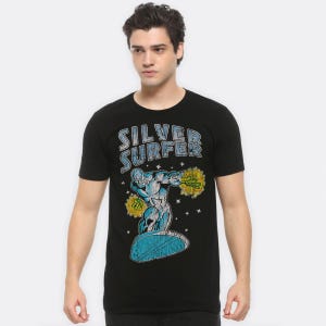 May include: Black t-shirt with a graphic of the Silver Surfer. The design features the words "Silver Surfer" in blue and white above the character. The Silver Surfer is shown in silver, riding a blue surfboard, with yellow energy bursts.