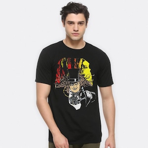 May include: Black t-shirt with a graphic print of the Penguin from Batman Returns. The graphic features the Penguin in his signature top hat and suit, with a yellow, red, and black background.