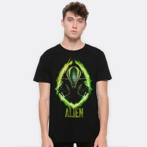 Könnte beinhalten: Schwarzes T-Shirt mit einer grünen und gelben Grafik der Alien-Kreatur aus dem Film-Franchise. Der Text "Alien" ist unter der Grafik gedruckt.