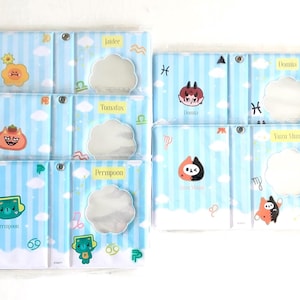 May include: Six light blue and white striped pouches, each featuring cartoon characters and a cloud-shaped mirror. The pouches are labelled with names such as "Jatdee" and "Domia". The design includes zodiac symbols and cloud motifs.