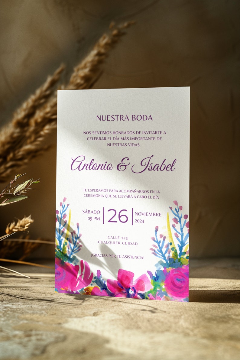 May include: A wedding invitation with a watercolor floral design in shades of pink, blue, and yellow. The invitation reads "Nuestra Boda" and includes the names "Antonio & Isabel", the date "Saturday, November 26, 2024", and the time "09 PM".