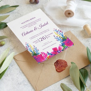 May include: A white wedding invitation with a floral design in shades of pink, purple, blue, and green. The invitation reads "Nuestra Boda" and includes the names "Antonio & Isabel" and the date "Sabado 26 | Noviembre 2024".