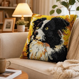 May include: A square throw pillow featuring a textured punch needle design of a black and white dog with a yellow and orange background. The dog has a white muzzle, chest, and forehead blaze, with black ears and patches around the eyes.