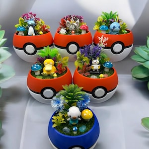 May include: Five Pokeball planters with different Pokemon characters inside. Each planter is a different color, red, white, and blue. The planters are filled with small plants and rocks.