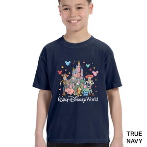 Puede incluir: Camiseta azul marino con un gr&aacute;fico colorido de los personajes de Toy Story frente a un castillo, con el texto "Walt Disney World". El dise&ntilde;o incluye a Woody, Buzz Lightyear y otros personajes.