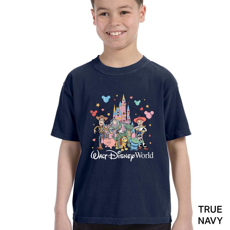 Puede incluir: Camiseta azul marino con un gr&aacute;fico colorido de los personajes de Toy Story frente a un castillo, con el texto "Walt Disney World". El dise&ntilde;o incluye a Woody, Buzz Lightyear y otros personajes.