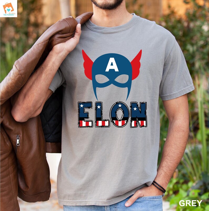 May include: A grey t-shirt with a blue and red Captain America mask and the word "ELON" in red, white, and blue with stars.