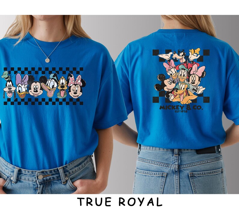 May include: A true royal blue t-shirt featuring a front graphic of six Disney character faces arranged in a horizontal row over a black and white checkerboard pattern. The back displays a larger group of characters with the text MICKEY & CO. EST 1928.