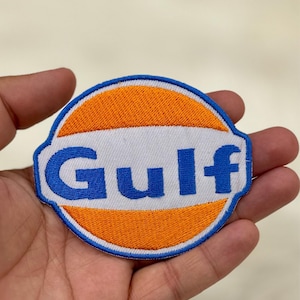 May include: An embroidered patch featuring the Gulf logo in blue and orange, with the word "Gulf" in white.