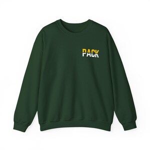 May include: A dark green sweatshirt with the word "PACK" printed on the front in white and yellow letters.