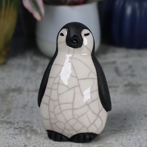 Penguin chick resting - ceramic raku fired sculpture