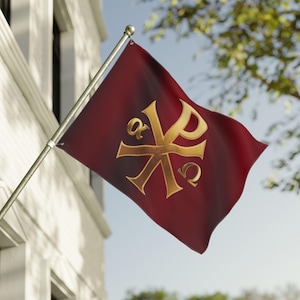 Può includere: Una bandiera bordeaux con un simbolo Chi Rho dorato, Alfa e Omega. La bandiera è montata su un'asta d'argento e sventola al vento. Lo sfondo comprende un edificio bianco e un albero con foglie verdi.