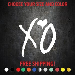 May include: White "XO" graphic with a heart replacing the "O" on a dark gray background. The text "CHOOSE YOUR SIZE AND COLOR" is above the graphic in red. A row of color options is at the bottom.