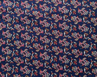 May include: A navy blue fabric with a paisley pattern in white, red, and yellow.