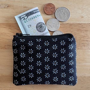 May include: A white ceramic mug with a black handle and the text "But First, Coffee" in a handwritten style. The mug is on a white surface. The mug is 4 inches tall.