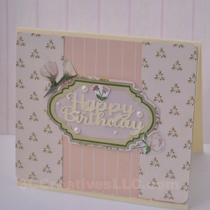 4 x 5.5 inch card in Peach floral and striped printed paper. Happy Birthday cutout in center  decorated with fussy cut flowers and white pearls .