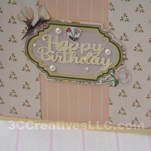 4 x 5.5 inch card in Peach floral and striped printed paper. Happy Birthday cutout in center  decorated with fussy cut flowers and white pearls .