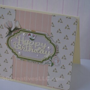 4 x 5.5 inch card in Peach floral and striped printed paper. Happy Birthday cutout in center  decorated with fussy cut flowers and white pearls .