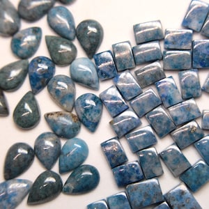 May include: A collection of blue and green gemstone cabochons in teardrop and rectangular shapes. The stones have a marbled appearance and are ready to be set in jewelry.