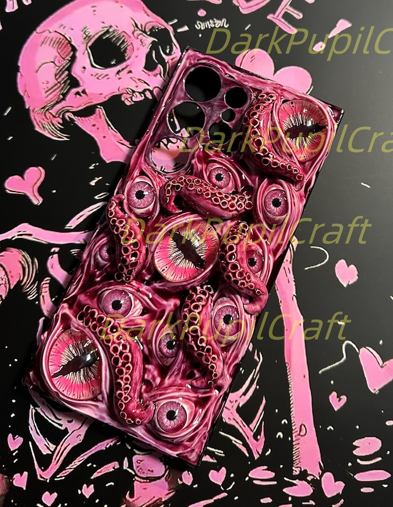 May include: A pink and black phone case with a 3D design of a pink octopus with multiple eyes. The octopus tentacles are textured and the eyes are glossy.