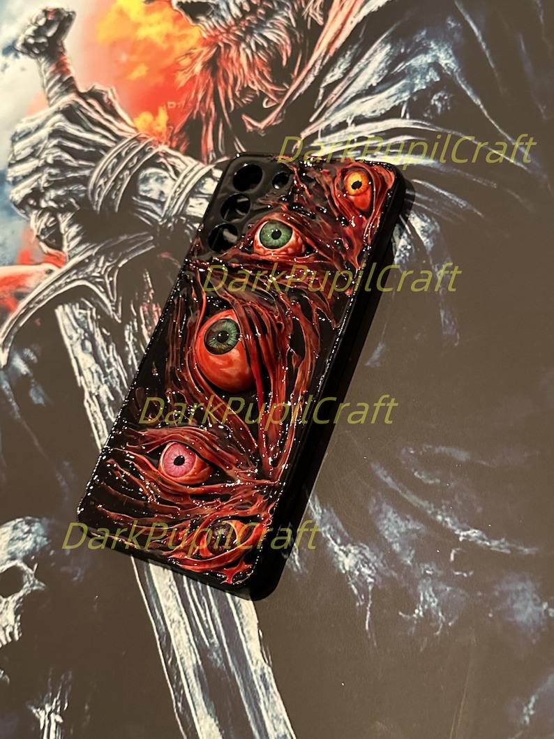 Puede incluir: Carcasa de tel&eacute;fono negra con un dise&ntilde;o rojo, blanco y negro con varios ojos. El texto "Dark Pupil Craft" es visible en la carcasa.