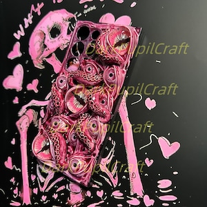 May include: A pink and black phone case with a skull and octopus design. The case has a textured surface and the text "What is Love!" is written on the top. The case is surrounded by pink hearts.