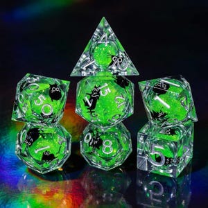 May include: A set of seven clear, multi-sided dice with a vibrant green interior and black cat silhouettes. The dice feature white numbers and are designed for tabletop gaming. The dice are arranged on a reflective surface.