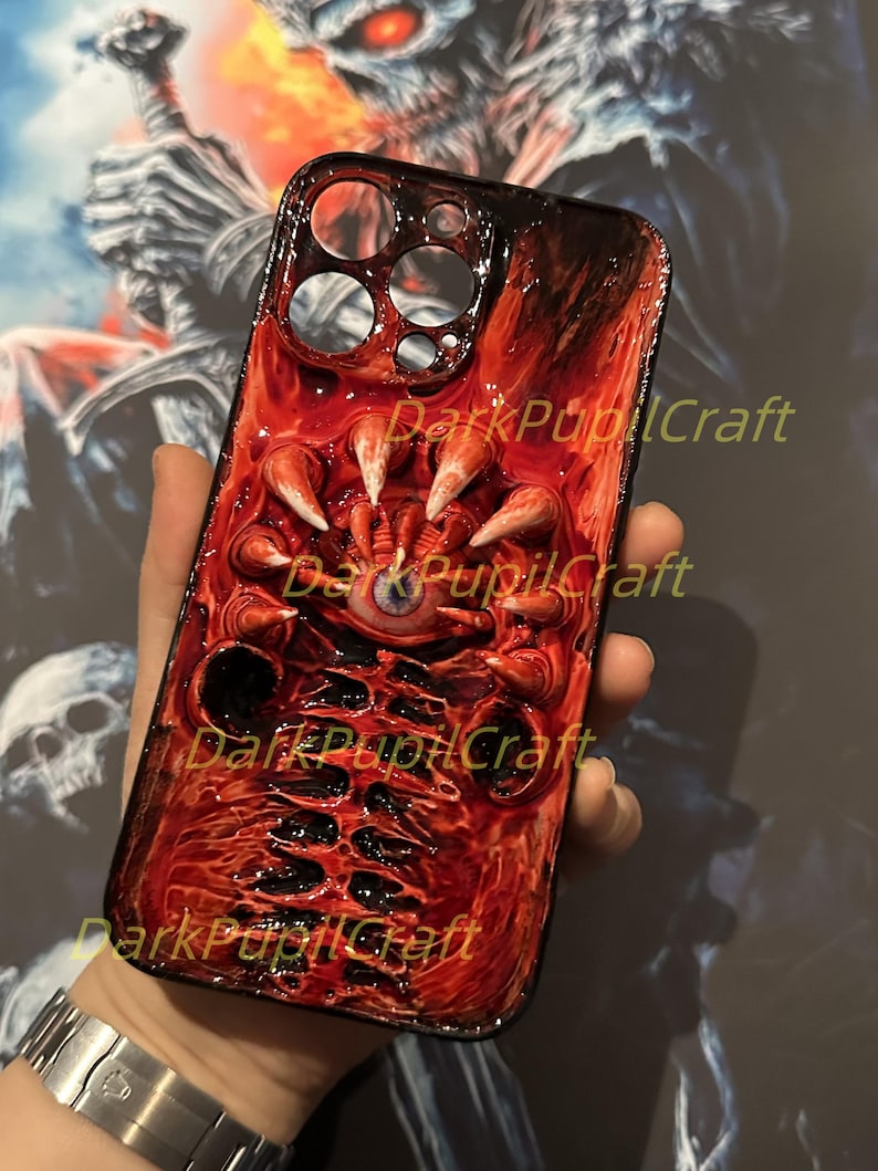 May include: A red and black iPhone case with a detailed 3D design of a monstrous eye and claws. The case has the text "DarkPupilCraft" printed on it.