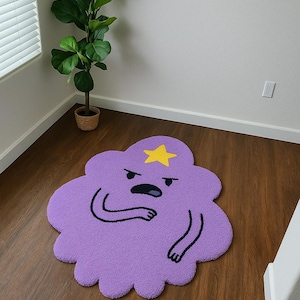 May include: A purple, cloud-shaped rug with a yellow star and a cartoon face. The rug is on a hardwood floor. A potted plant is in the background near a window with blinds.