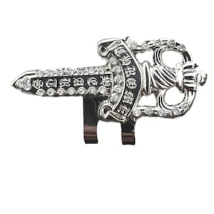 May include: A white ceramic mug with a black handle and the text "But First, Coffee" in a bold, black font. The mug is set against a blurred background, suggesting a cozy setting.