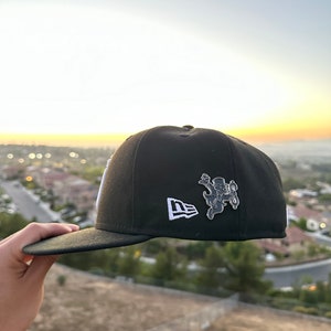 May include: A white ceramic mug with a black handle and the text "But First, Coffee" in a black, handwritten-style font. The mug is on a white surface.